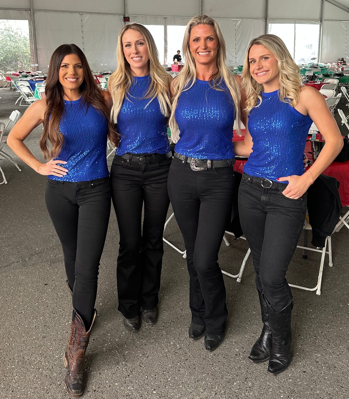 Four Mandi's Models in blue sequin tops, black jeans and boots inside a banquet tent