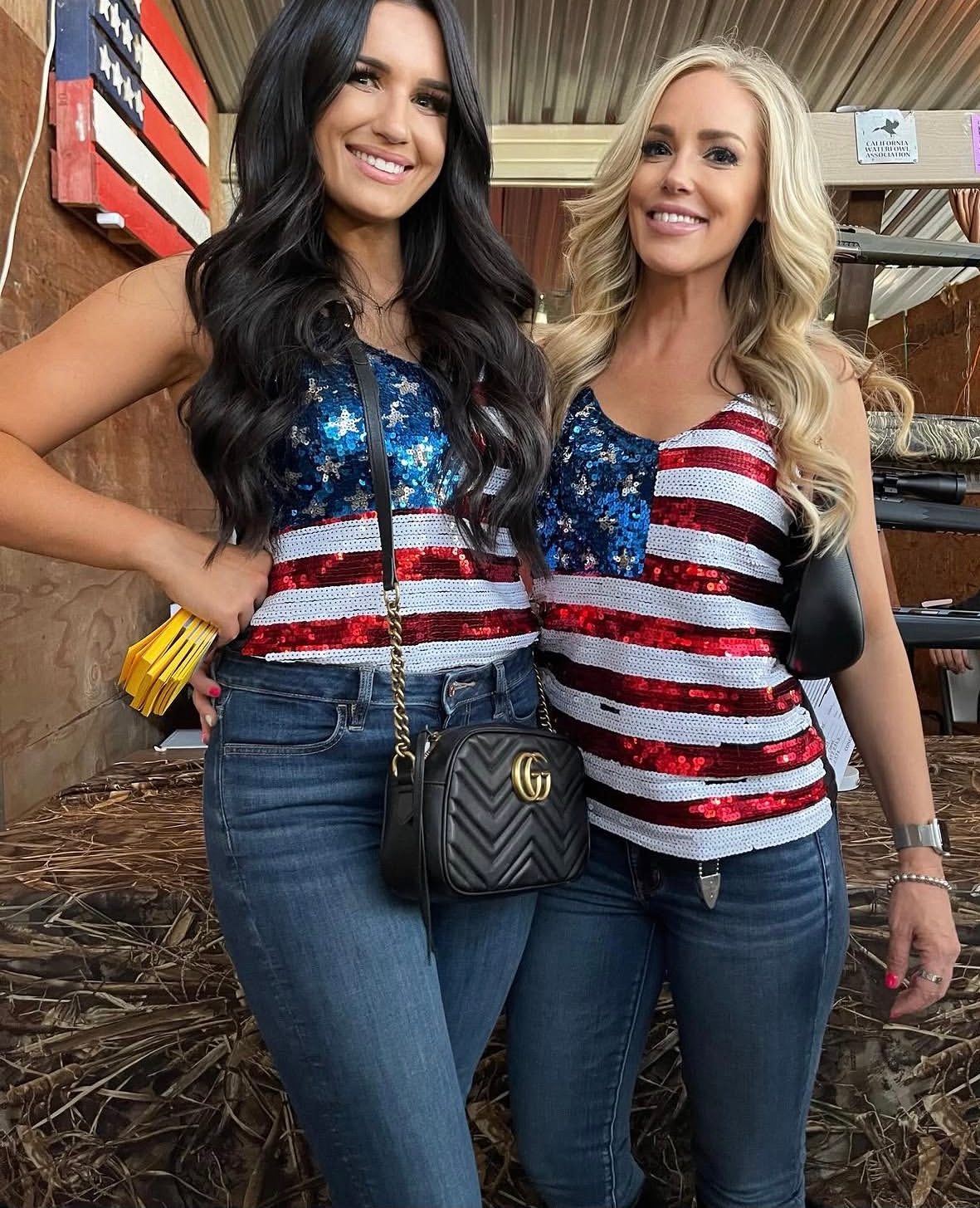 Two Mandi's Models in flag sequin tops and jeans in a covered barn-style venue